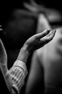 A black and white photo of a person holding their hands together